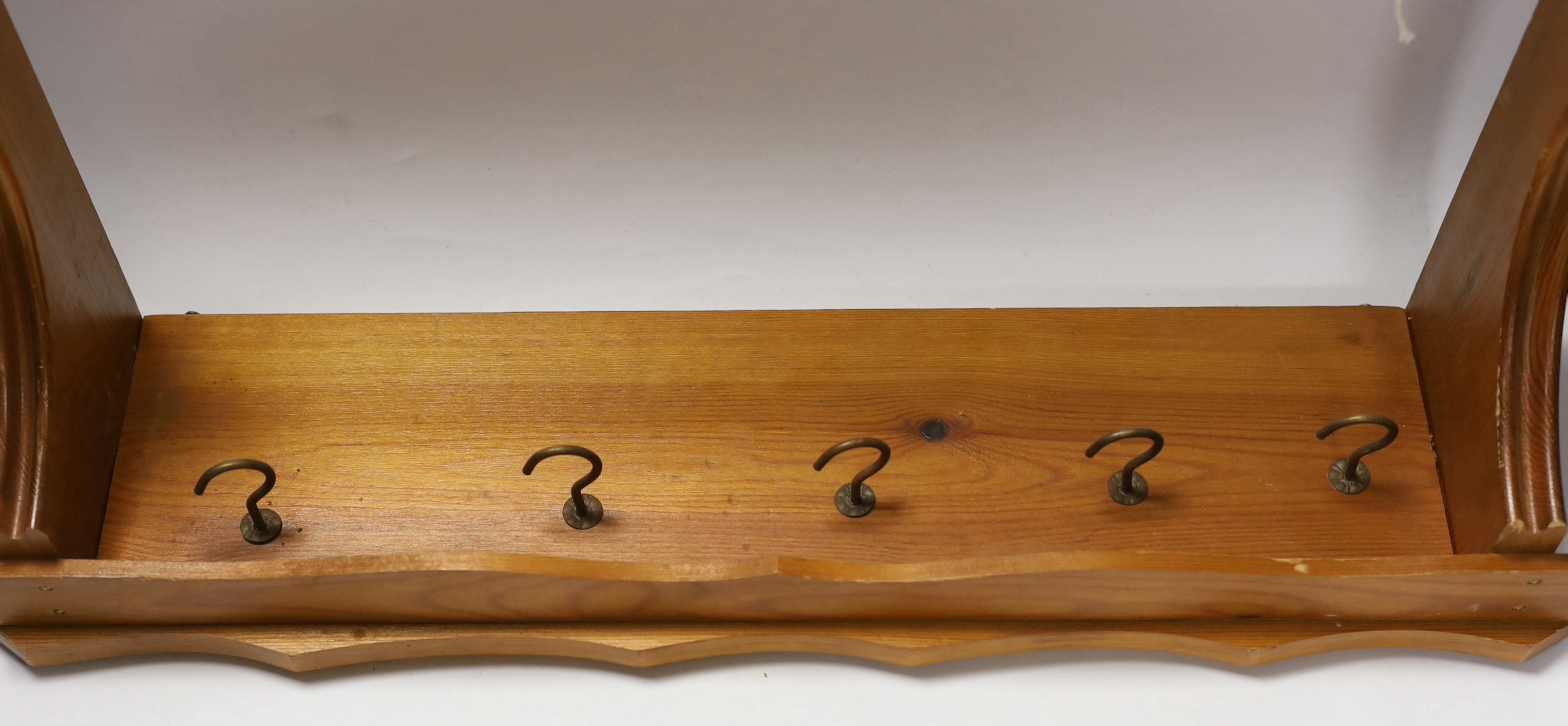 A graduated set of five French copper and cast iron saucepans with pine hanging rack, 57cm wide